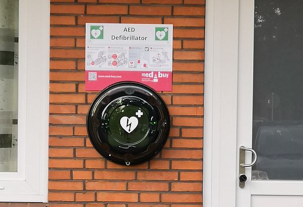 AED im runden Wandkasten mit Kurzanleitung