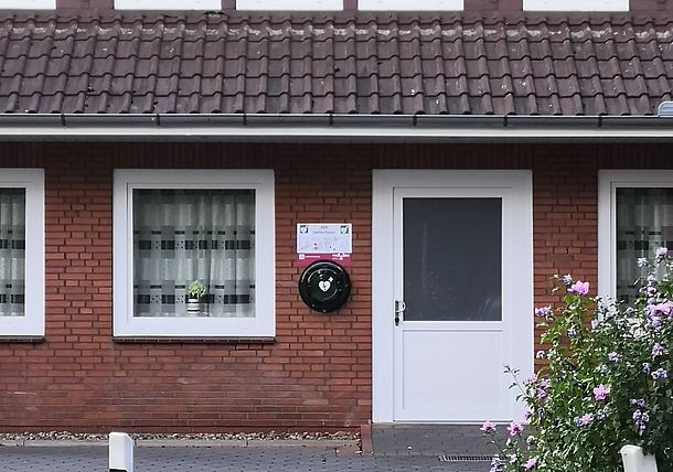 Öffentlicher AED im runden Wandkasten links neben dem Eingang zum Dorfgemeinschaftshaus
