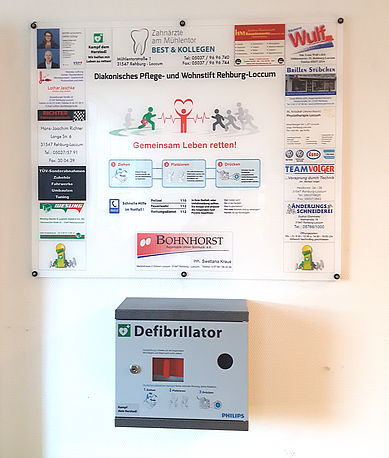 AED im weißen Wandkasten mit Informationsschild